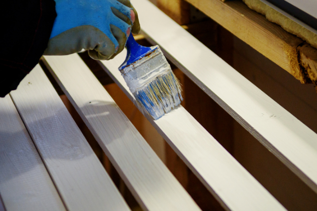 Deck Painter with a brush painting in white