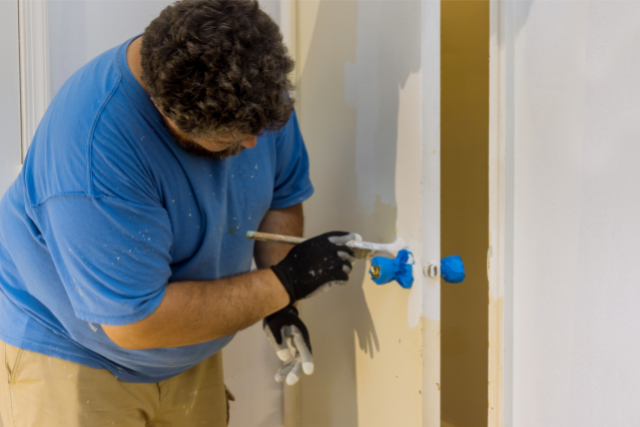 Worker doing Interior Painting of a door